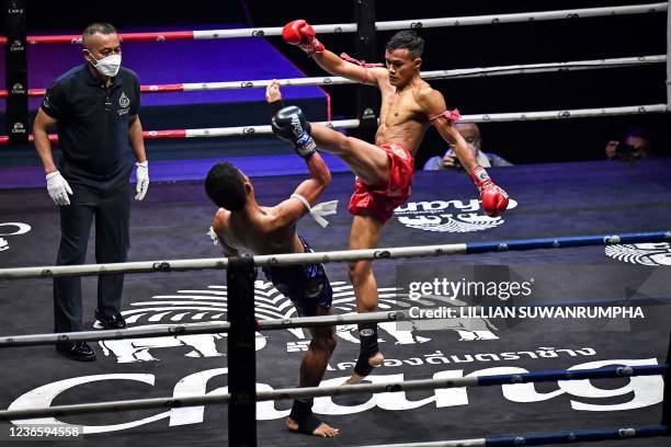 This photo taken on November 13, 2021 shows Muay Thai boxers competing in the ring at Lumpinee Stadium in Bangkok. - Out with the gamblers and harsh...