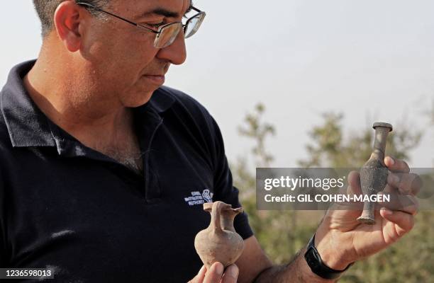 Israel Antiquities Authority archaeologist Saar Ganor presents pottery finds at an excavation site in Lachish Forest near the southern city of Kiryat...