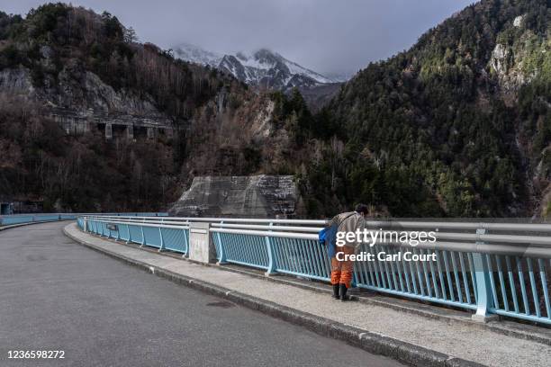 Man looks over the side of Kurobe dam, the tallest in Japan at 186 metres, on November 11, 2021 in Ashikuraji, Japan. Japanese government experts...