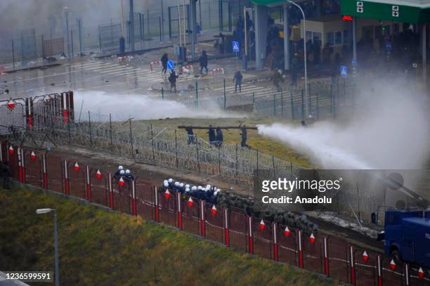 Polish forces use water cannons and tear gas to disperse irregular migrants in the buffer zone between Belarus and Poland border on November 16, 2021...