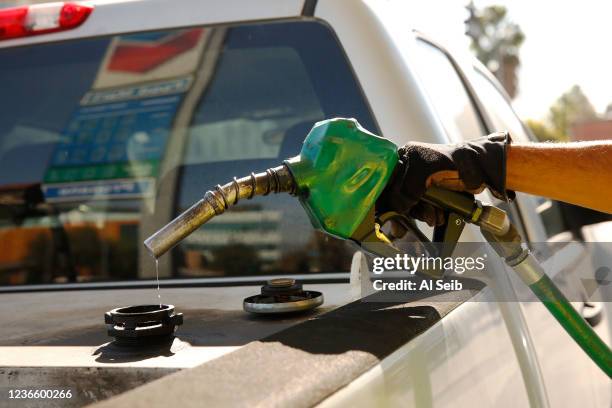 Daniel Gomez working for UC Riverside makes every drop count as drivers select from various fuels all priced over $6 dollars at a Chevron Gas Station...