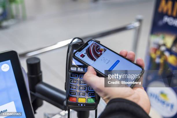 Customer uses Apple pay mobile payment at a contactless payment terminal inside an Albert hypermarket, operated by Koninklijke Ahold Delhaize NV, at...
