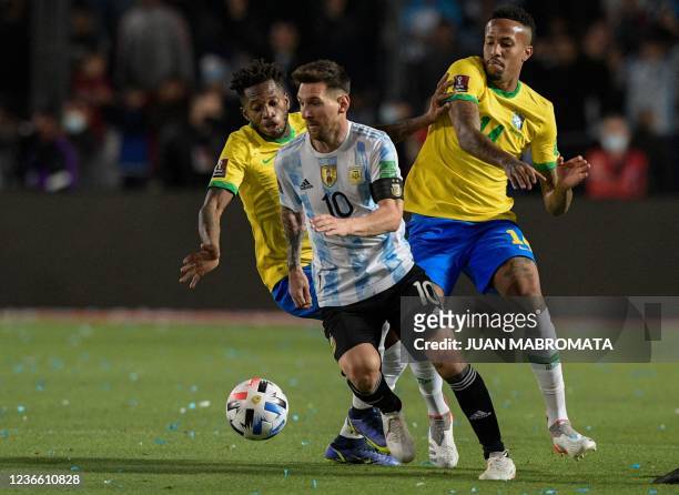 Argentina's Lionel Messi drives the ball past Brazil's Fred and Eder Militao during their South American qualification football match for the FIFA...