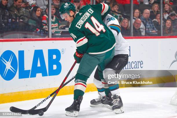 Mario Ferraro of the San Jose Sharks battles for the puck with Joel Eriksson Ek of the Minnesota Wild during the game at the Xcel Energy Center on...