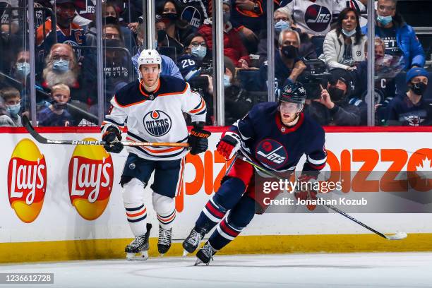 Kyle Turris of the Edmonton Oilers and Andrew Copp of the Winnipeg Jets keep an eye on the play during second period action at the Canada Life Centre...