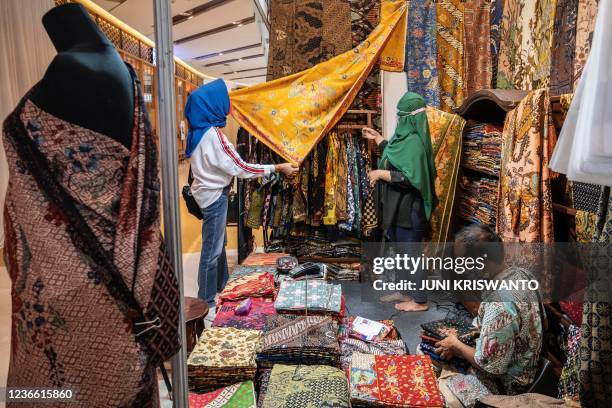 Customer looks at a stall selling traditional batik fabric and clothing during a handicraft exhibition at a shopping centre in Surabaya on November...