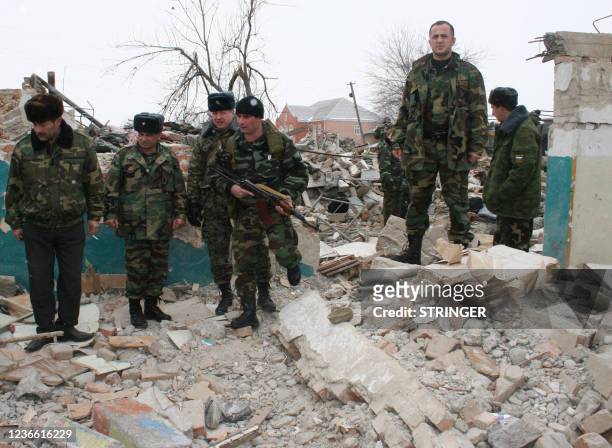 Security force soldiers walk at the site of the explosion of a two-storey military barracks in the Chechen village of Kurchaloi, some 30 kms from...