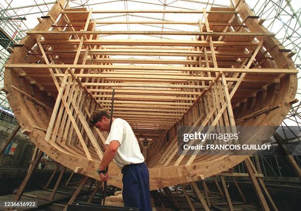 Un charpentier participe, le 10 août à l'arsenal de Rochefort, à la construction à l'identique de l'ossature de la frégate l'Hermione, à bord de...