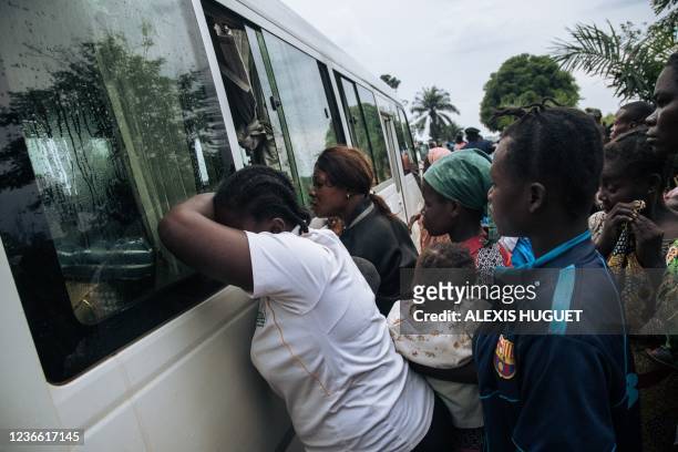 Central African refugees cry as their relatives and friends are bussed from Inke camp to the airport in Gbadolite, northern Democratic Republic of...