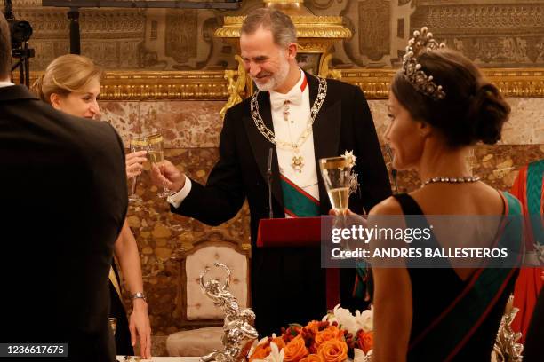 Spain's King Felipe VI toasts with Italian President's daughter Laura Mattarella during an official state dinner at the Royal Palace of Madrid, on...