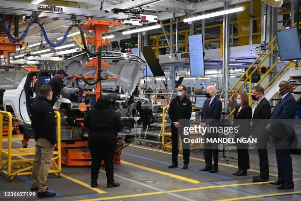 President Joe Biden stands on the GMC Hummer EV production line as he tours the General Motors Factory ZERO electric vehicle assembly plant with...