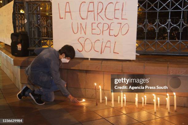 Person lights a candle at the Central Square of Cuenca during a vigil to demand justice for activist Victor Guaillas, victim of the November 14...