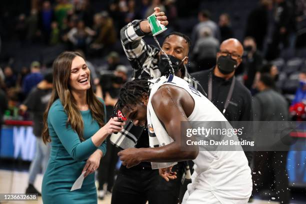 Josh Okogie pours water on Anthony Edwards of the Minnesota Timberwolves after the game against the Sacramento Kings at Target Center on November 17,...