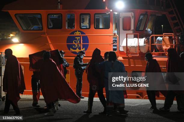 Emergency personnel assist migrants to disembark from a maritime rescue vessel in the port of Arguineguin, after their rescue off the coast of the...