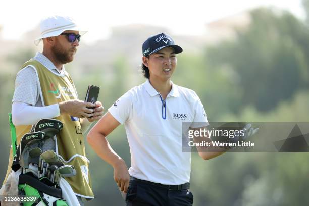Min Woo Lee of Australia with his caddie William Harke at the 3rd hole during Day One of The DP World Tour Championship at Jumeirah Golf Estates on...