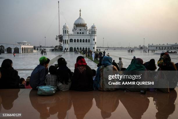 Sikh pilgrims sit inside the Gurdwara Darbar Sahib complex on the eve of the birth anniversary of Guru Nanak, founder of Sikhism, in Kartarpur near...