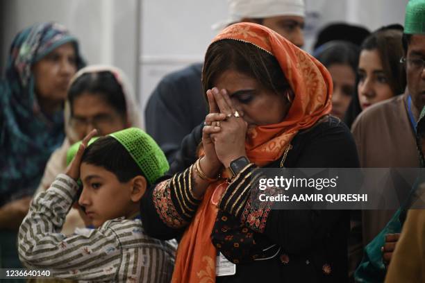 Sikh pilgrims offer prayers on the eve of the birth anniversary of Guru Nanak, founder of Sikhism, at the Gurdwara Darbar Sahib in Kartarpur near the...