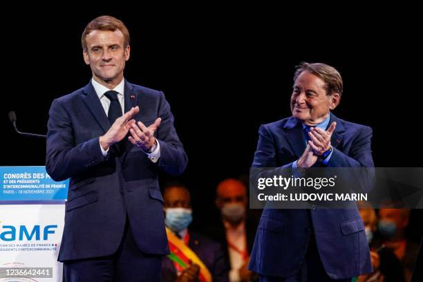 France's President Emmanuel Macron applauses next to AMF Vice-President and Mayor of Issoudun Andre Laignel at the end of the closing event of the...