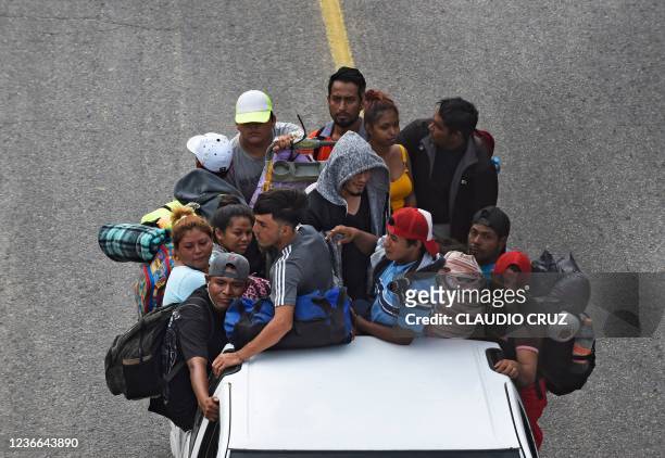Migrants heading in a caravan to the US, ride on the back of a truck in El Arenal, Sayula de Aleman municipality, Veracruz state, Mexico, on November...