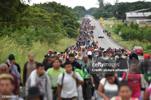Dpatop - 16 November 2021, Mexico, Veracruz: Numerous people from Central America walk together along a rural road towards the US border. A new group...