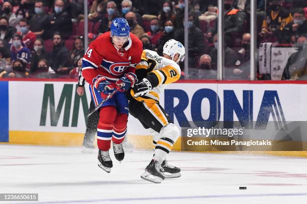 Nick Suzuki of the Montreal Canadiens jumps behind Chad Ruhwedel of the Pittsburgh Penguins during the first period at Centre Bell on November 18,...
