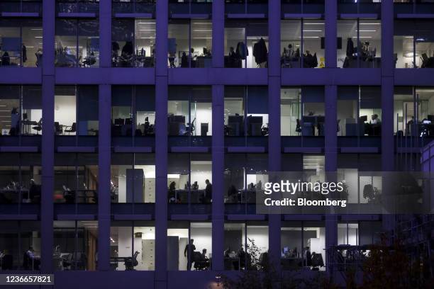 Employees work at their desks inside an office building in London, U.K., on Thursday, Nov. 18, 2021. U.K. Prime Minister Boris Johnson said the City...