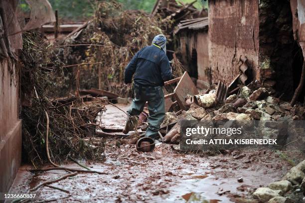 Man walks in Kolontar about 160 kms southwest of Budapest, on October 6, 2010 after a wave of toxic red mud swept through the small village two days...