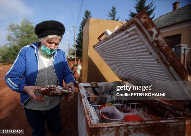 Local elderly woman opens her fridge as she stands in front of her house in the flooded town of Devecser, 150 km west of Hungarian capital Budapest...