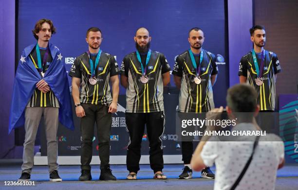 The Kosovan winners of the Dota 2 tournament stand on stage with their medals at the end of the finals of the 13th Esports World Championship in the...