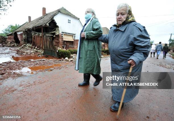 Residents return to check their homes in Kolontar about 160 kms southwest of Budapest, on October 6, 2010 after a wave of toxic red mud swept through...