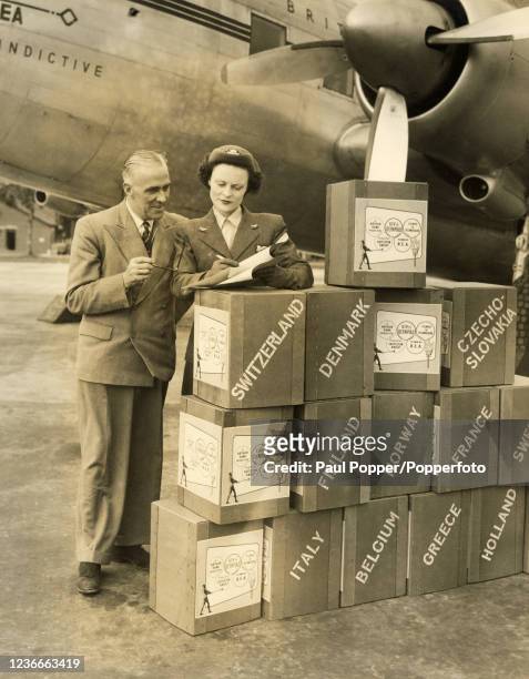 British film producer Castleton Knight with air hostess Wendy McNicol checking the consignment of his documentary film of the Summer Olympic Games in...