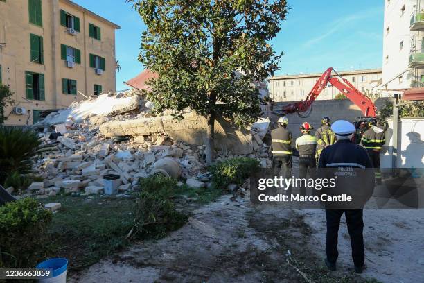 Firefighters watch an excavator as it removes the rubble of the completely collapsed building in San Felice Cancello, in the province of Caserta,...