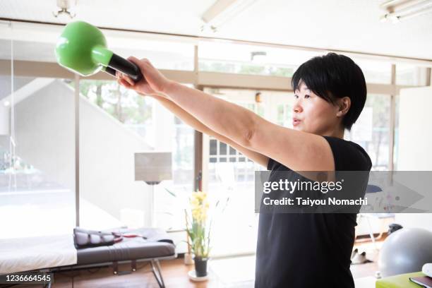 women who use dumbbells to work out - lichaamsbouw stockfoto's en -beelden