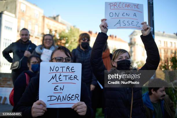 Two women brandish placards reading 'Our job is in danger' and 'Precarity we're fed up' .Educators on strike gathered in Toulouse near the Prefecture...