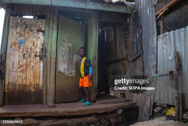 Young boy stands outside the doors of a local latrine in Kibera Slums. World Toilet Day is an official United Nations international observance day on...