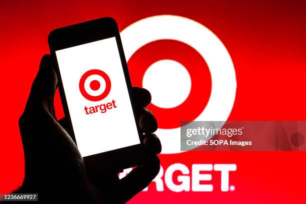 In this photo illustration, a Target Corporation logo is seen on a smartphone screen with a Target Corporation logo in the background.