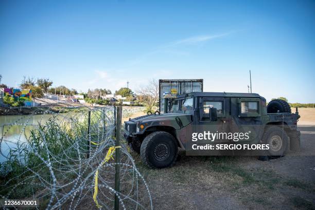 Shipping containers and High Mobility Multipurpose Wheeled Vehicle military vehicles line the area near the Rio Grande river on November 19, 2021 in...