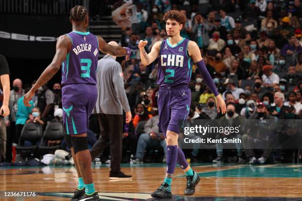 Terry Rozier of the Charlotte Hornets high fives LaMelo Ball of the Charlotte Hornets during the game against the Indiana Pacers on November 19, 2021...
