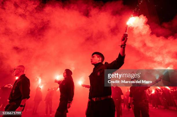 Far right wing members and supporters of La Falange carrying flares during a demonstration marking the 85th anniversary of the death of Jose Antonio...