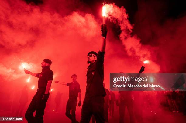 Far right wing members and supporters of La Falange carrying flares during a demonstration marking the 85th anniversary of the death of Jose Antonio...