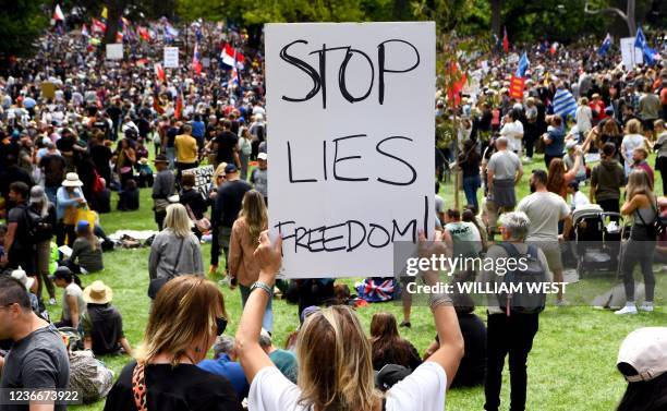 People hold up placards during a rally against Covid-19 lockdown and vaccination measures in Melbourne on November 20, 2021.