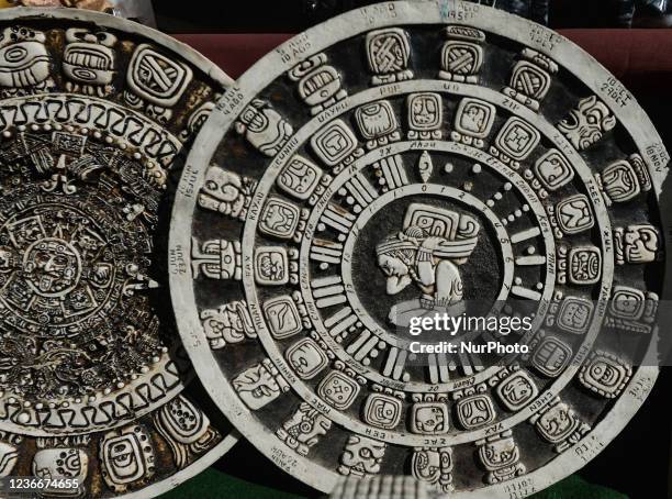 Maya calendar of Mayan or Aztec vector hieroglyph signs and symbols on display at a stand with locally made gifts and souvenirs seen next to the...