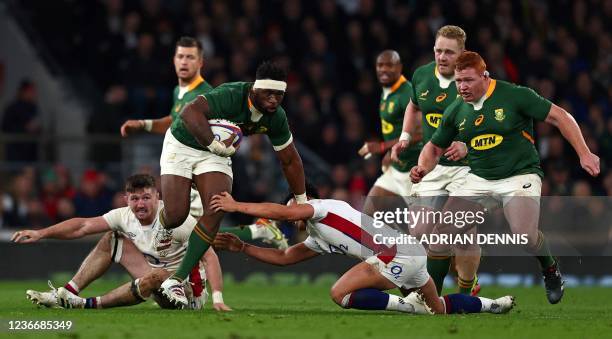 South Africa's flanker Siya Kolisi avoids a tackle from England's fly-half Marcus Smith during the Autumn International friendly rugby union match...