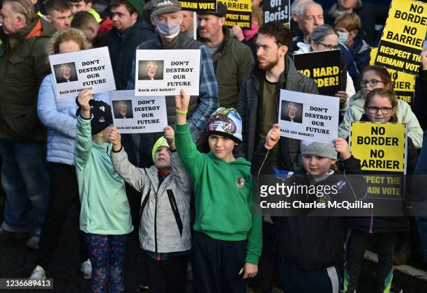Children hold up Back Off Boris placards as Border Communities against Brexit protestors take part in a demonstration on November 20, 2021 in Newry,...