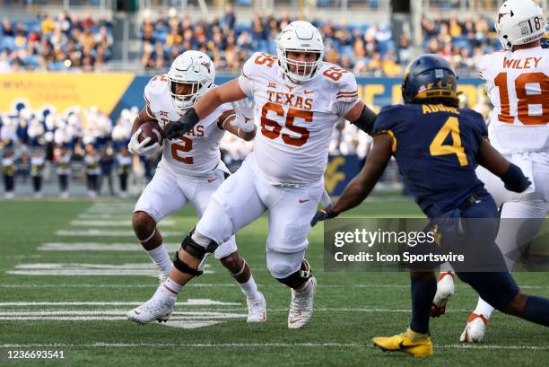 Texas Longhorns running back Roschon Johnson uses offensive lineman Jake Majors as a blacker to run the ball during a game between the West Virginia...