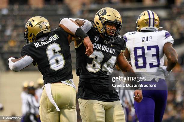 Cornerback Mekhi Blackmon and defensive end Mustafa Johnson of the Colorado Buffaloes celebrate after Blackmon defended a pass intended for tight end...