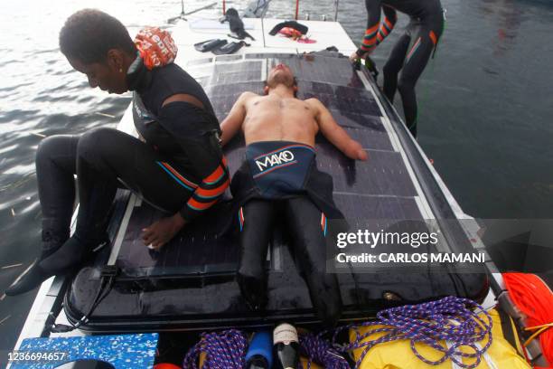 French Paralympic swimmer Theo Curin and French former Olympic swimmer Malia Metella rest after arriving to the Uros Island in Peru, on November 20,...