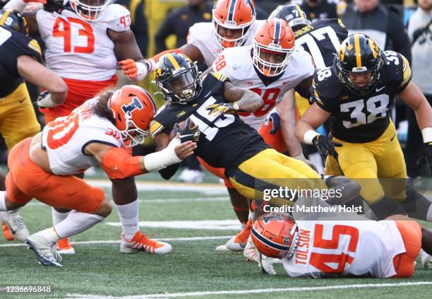 Running back Tyler Goodson of the Iowa Hawkeyes is tackled during the second half by defensive back Sydney Brown and linebacker Khalan Tolson of the...