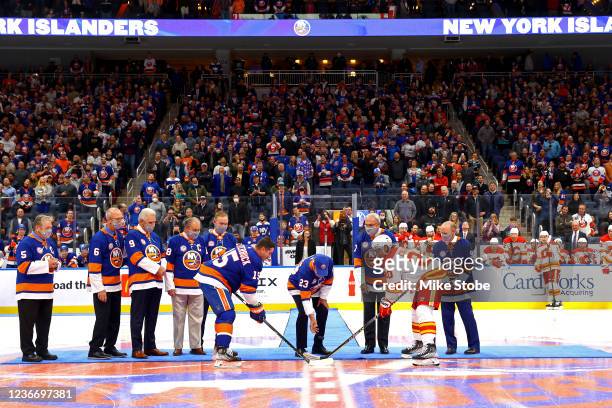 New York Islanders hall-of-fame player Bobby Nystrom drops the ceremonial puck between Cal Clutterbuck of the New York Islanders and Blake Coleman of...