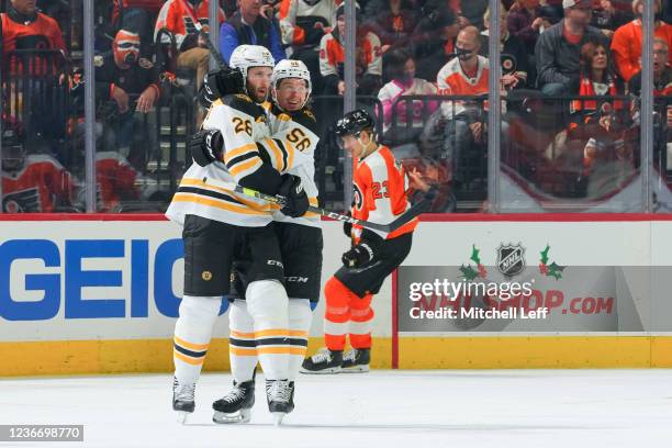 Derek Forbort of the Boston Bruins celebrates his goal with Erik Haula in front of Oskar Lindblom of the Philadelphia Flyers in the second period at...